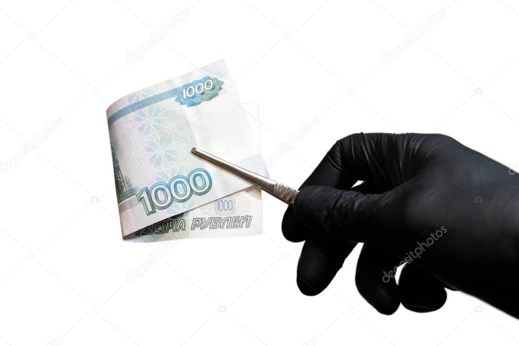 A close-up of a man's hand in a black glove that holds one thousand Russian rubles with tweezers. The concept of paid medicine and corruption, violation of the law and the work of a criminalist or a scientific laboratory assistant. Copy space. Isolat