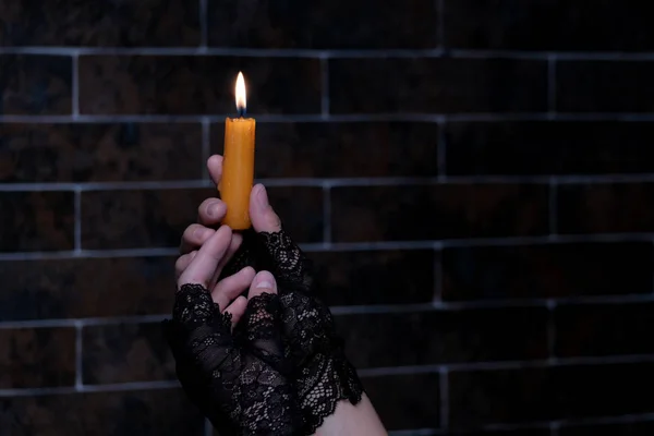 Eine Brennende Kerze Weiblichen Händen Backsteinmauer Hintergrund Schwarze Handschuhe Thema — Stockfoto