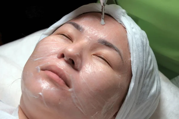 The procedure of disincrustation. Hardware cosmetology. Muslim woman with her eyes closed. East girl on the procedure of deep cleansing of the skin in the beauty salon. Shallow depth of field. Closeup.