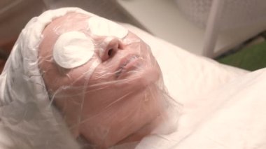 Cilt buğulaması ve gözenekleri genişleterek Kosmetoloji prosedürü. Sıcak buhar bir kozmetik salonda bir kadın yüzü yönlendirilir. Sağlık ve güzellik kavramı.