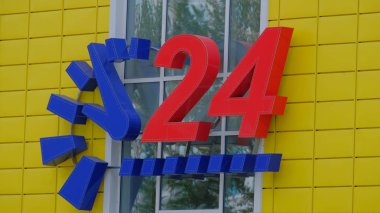 Bir mavi saat ve büyük kırmızı sarı Market 24 günlük servis numaraları.