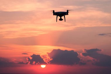 Konsept Fotoğraf ve video ile doğa havada dron yardımıyla. Pembe bir arka plan. Uzay kopyalayın. Bir quadrocopter günbatımı güzel bulutlar ile uçar.