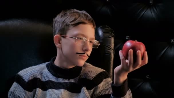Jovem Óculos Com Bigode Colado Senta Uma Poltrona Preta Pega — Vídeo de Stock