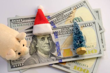 Ne kadar para Amerikalılar Yılbaşı tatil günlerinde Franklin 100 dolar, pembe oyuncak yumuşak piglet, bir hatıra Noel ağacı ve Santa Claus şapka harcamak. Finans ve domuz yılı borç kavramı.