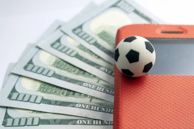 Beş yüz ABD Doları bir arka plan kırmızı bir durumda bir cep telefonu ekranının futbol Hediyelik eşya topla. Spor bahisleri ile bir smartphone kavramı.