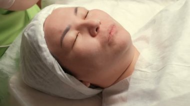 Fizyoterapi yüz gençleştirme yordam Müslüman bir kadının çehresini Close-up. Güzellik uzmanı yüksek frekanslı pulsed alternatif akımları ile bir cihaz kullanın. Darsonvalization.