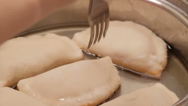 Νοικοκυρά ψητά chebureks στο τηγάνι. Τηγανιτό flatbread piadina naan πίτα τορτίγια shelpek cheburek. Καυκάσου και της Ανατολικής τροφίμων. — Αρχείο Βίντεο
