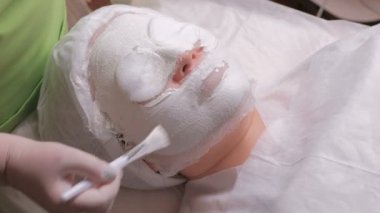 Cilt temizliği ve gençleşme. Bir güzellik elinde bir kadının yüzünde maske daralan bir aljinat gözenekleri empoze. Medikal Kozmetik prosedür.