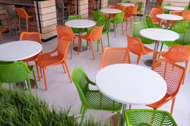 Bir kafe, Havaalanı veya aile fast food restoran insanlar olmadan soyut iç. Turuncu ve yeşil sandalye beyaz bir food court tablolarda etrafında. Kopya alanı.