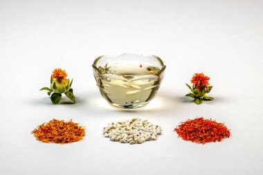 Sarı, kırmızı kurutulmuş yaprakları, çiçek, tohum ve yağ beyaz bir arka plana dayanır. Aspir Carthamus tinctorius. Kopya alanı.