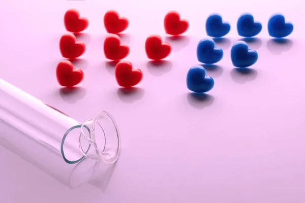 Abriveura IVF from red hearts and a broken test tube in the foreground on a pink background. Concept of unsuccessful in vitro fertilization Copy space. The theme of the shattered dream of a newborn.
