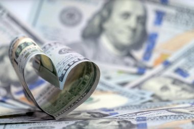 Bir kalp şeklinde yüz dolarlık banknot ABD. Para arka plan. Uzay kopyalayın. Kavram mali sevgi ve Sevgililer günü için bir hediye.