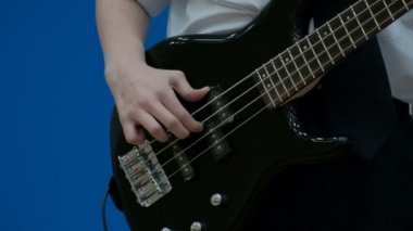 Siyah Elektro gitar çalmak adam teen bas gitarist. Yakın çekim. Bir gencin parmak bas gitarda ipleri. Gençlik müzikal Tema kavramı.