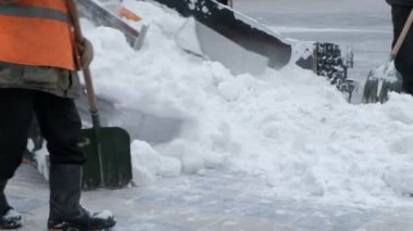 Sokaklarda kar kaldırma. Kürek kar temizleme aracı ve yol işçilerle Close-up. İnsanlar ve arabalar. Kar bolluğu. Kış.