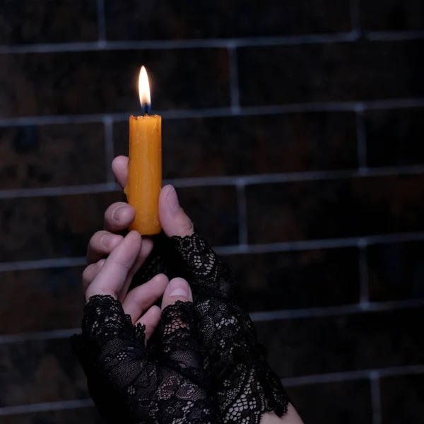 Burning Candle Female Hands Black Gloves Brick Wall Background Close — Stock Photo, Image
