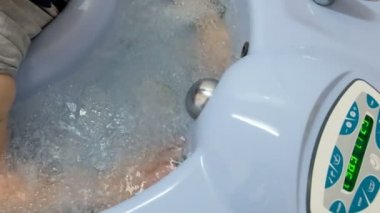 Eller yukarı. Hidro masaj tedavi köpük banyosu içinde yaşlı bir kadın üst ekstremite.