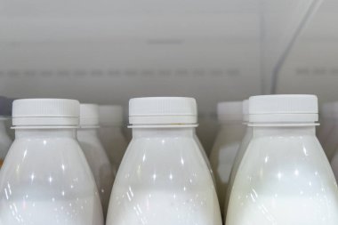 Plastik şişe süt mağaza rafındaki ile. Uzay kopyalayın. Beyaz arka plan.