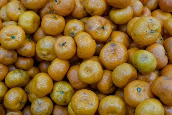 Background of bad citrus in the store. Spoiled tangerines. Rotting fruit goods at the grocery store.