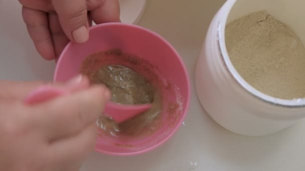Preparación de mascarilla antienvejecimiento de algas. esteticista profesional mezcla los ingredientes en una taza de color rosa. Salud y belleza. Primer plano . — Vídeo de stock