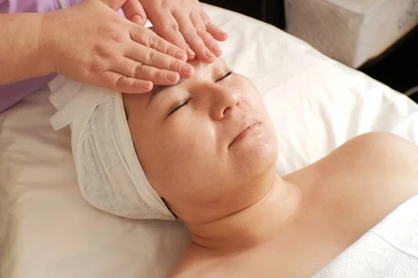 Schoonheidsspecialiste bereidt de vrouw gezicht voor cosmetische ingrepen. Close-up. De procedure voor de toepassing van de vochtinbrengende crème in de schoonheidssalon. — Stockfoto