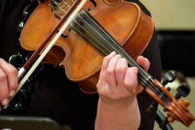 Keman çalmak bir kadın. Parmaklar dizeleri kavrama ve yay tutun. Yakın çekim. Sığ derinlik-in tarla. Seçici odak. Müzikal Tema.