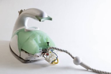 Ev aletleri tamiri. Yeşil elektrik demir demonte. Elektrikli cihaz ne de beyaz bir arka plan. Kopya alanı.