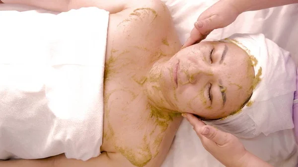 Cosmetische gezichtsmasker op basis van groene algen. Ontspannen Aziatische vrouw rust in spa. Cosmetologie. Zorg voor lichaam en gezicht. Spa-behandelingen. — Stockfoto