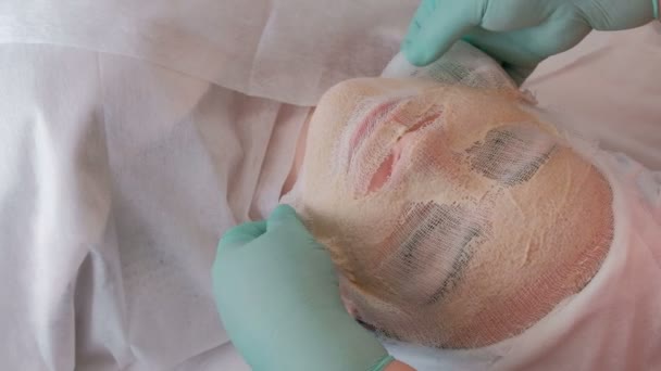 Handen Van Een Schoonheidsspecialiste Handschoenen Verwijderen Het Reinigende Masker Uit — Stockvideo