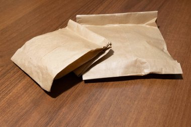 Paper bags of products from the store are on the table. The concept of ecology and packaging, production and use of non-plastic products. Copy space. Close-up. clipart