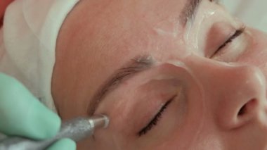 Bir güzellik eller genç bir kadının göz çevresi elektrotlar harcamak. Microcurrent masaj. Güzel kız kozmetik güzellik salonu içinde yordam. Yakın çekim. Donanım kozmetik.