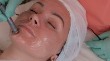 Güzel kız kozmetik güzellik salonu içinde yordam. Enjeksiyon tedavisi yok. Galvanik akım kadın yüzü deri ile bir elektrot bir güzellik uzmanı elinde kullanın.