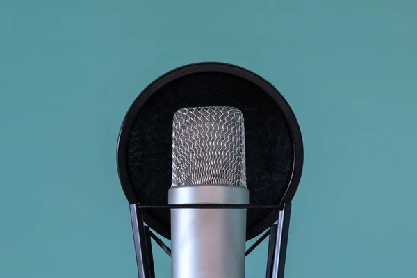 Profesionální studiový mikrofon s pop filtrem a tlumič na modrém pozadí. Pojem vysoce kvalitní zvuk a nahrávání hlasu. Detail. Kopírovat prostor. — Stock fotografie