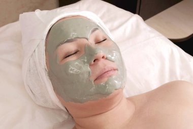 Yüzünde aljinat maskesi olan Asyalı bir kadın. Kaldırma maskesi, Spa'da gençleşme. Kozmetik prosedür. Sağlık ve güzellik