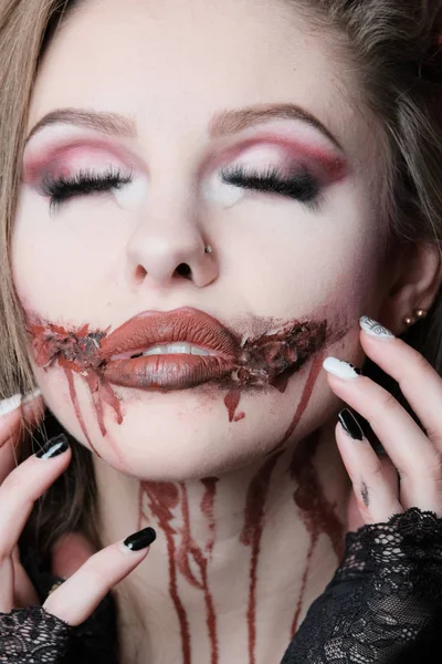Scary bloody makeup. Portrait of a sexy girl with long hair with closed eyes. Concept for Halloween, the feast of All Saints or a costume carnival. — Stock Photo, Image