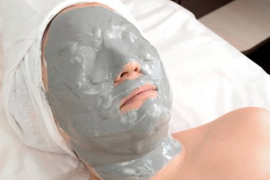 Aljinat kırışıklık karşıtı maskeli kız. Güzellik salonunda dinlenirken yatan bir kadının yakın çekim. Evde veya kozmetoloji merkezinde spa uygulamaları.