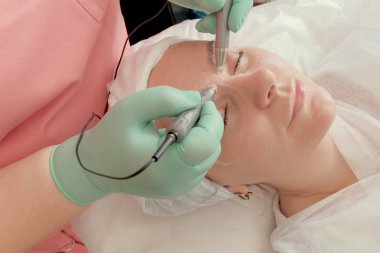 Göz altındaki morluklara karşı elektriksel uyarılma işlemi. Güzellik salonunda göz bakımı. Yüz temizleme Kozmetoloji.