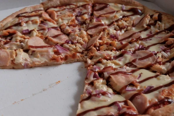 Pizza med skinka och ketchup utan två stycken är i lådan. Annonsera traditionella italienska rätter. Pizza dag. — Stockfoto