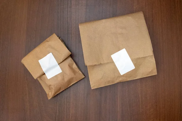Twee bruine kleur papieren zak. Houten achtergrond en textuur. — Stockfoto