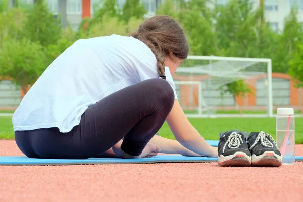 Clases de yoga al aire libre. La chica está ocupando en forma física en un gran primer plano Mat deportes. Estiramiento. Deporte. Aptitud — Foto de Stock