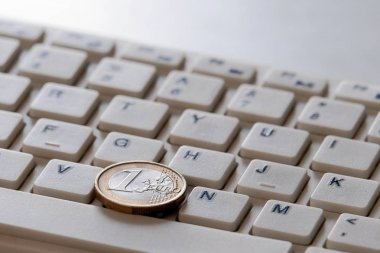 Bilgisayar klavyesi yakın çekim bir Euro sikke. Online satış iş konsepti. Yatırım ve promosyon online katkı. Kopyalama alanı.
