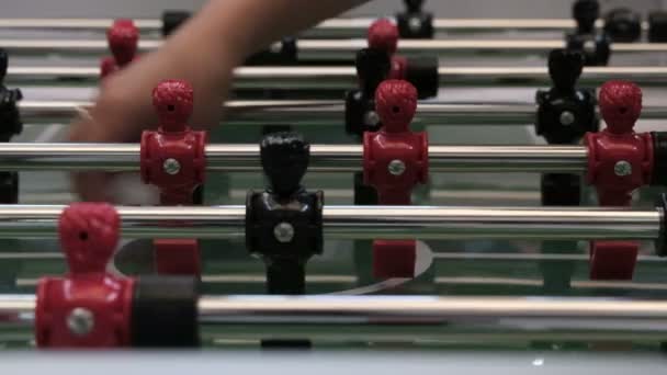 Table soccer. Foosball. Female hand lays a white ball on the center of the field of a board game in football. Close-up. Figures of red and black color. Popular team game. Entertainment and lifestyle. — Stock Video