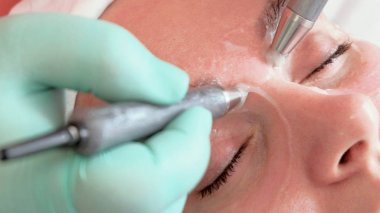 Morluklara karşı göz çevresine masaj. Kadınlar için güzellik salonunda mikrocurrent yüz tedavileri. Close.