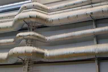 Gri gümüş arka plan. Teknik oda veya fabrika binalarının duvarı. Boru ve haberleşme üretim tesisleri.