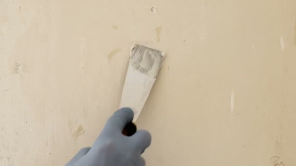 戴蓝色手套的修理工手用腻子刀贴在墙上的一个洞里 现代维修技术 窗户的自然照明 — 图库视频影像