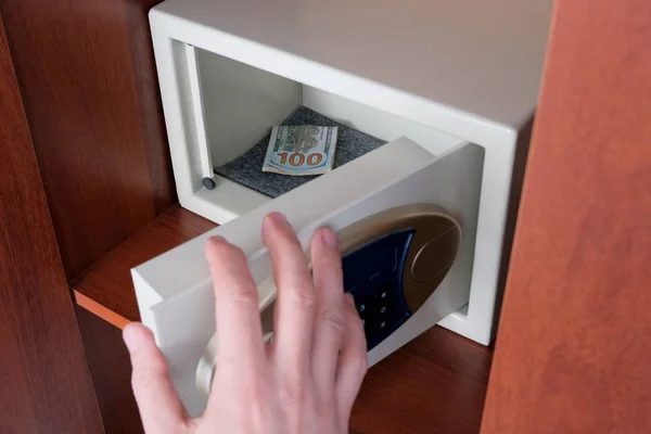 The man closes the safe with the money. Jewelry is protected in a Bank safe with a safe code lock at home and in the office. — Stock Photo, Image