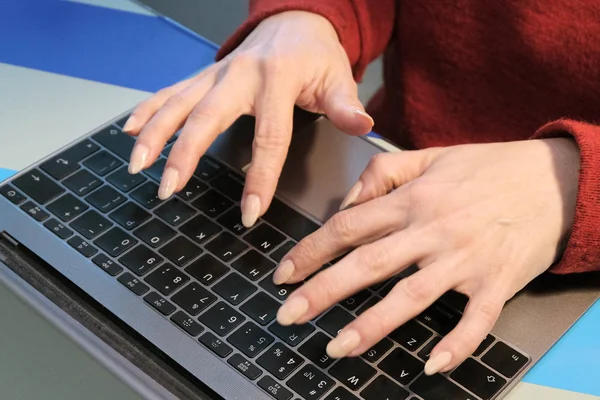 La fille travaille sur un ordinateur portable. Deux mains féminines sur un clavier d'ordinateur noir. Le concept de chef de bureau ou de femme d'affaires . — Photo
