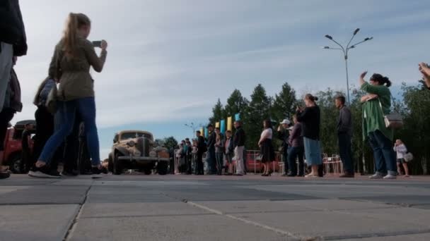 Kazachstán, Kostanay, 2019-06-20, obyvatelé města doprovázeni účastníky automatické rally v retro autech z centrálního náměstí. Peking k pařížskému problému. Chevrolet. — Stock video