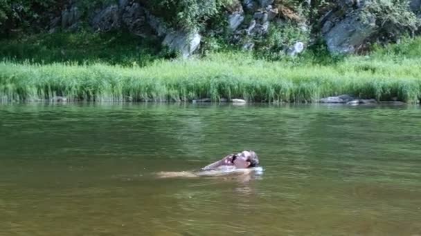 Хлопчик спілкується на смартфоні під час плавання у воді. Сучасні водонепроникні мобільні гаджети. Підліток плаває на річці і розмовляє по телефону . — стокове відео