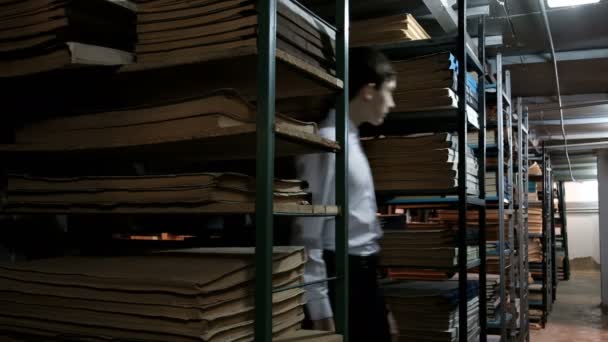 Adolescente Camisa Branca Está Procura Rapazinho Entre Prateleiras Com Livros — Vídeo de Stock