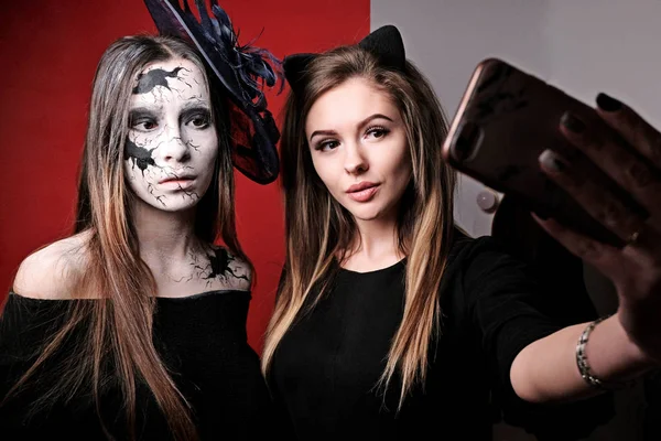 Halloween makeup. Two girls make selfies before a party on All Saints Day. The image of a cracked doll. — Stock Photo, Image